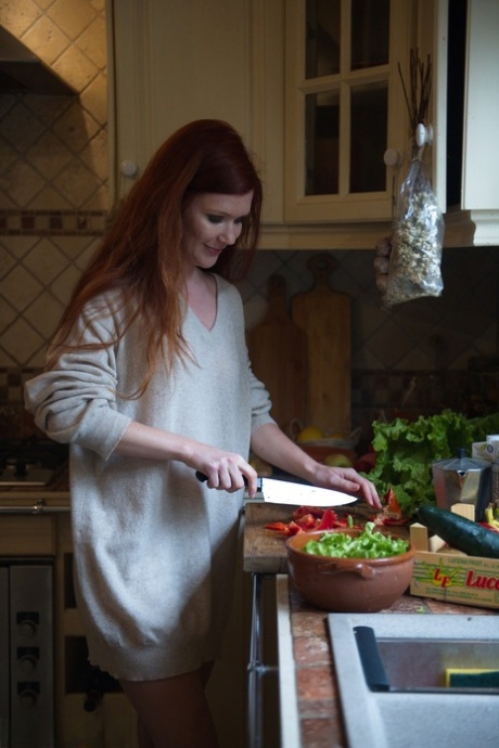 Glam model Mia Sollis sports long red hair while eating a banana in a ballcap 55204162