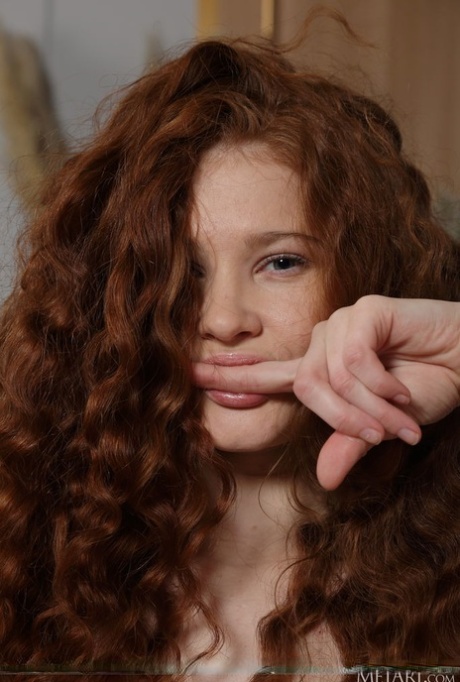 Young girl with wavy red hair Foxy Sofilie gets bare naked on a sofa bed 68825974