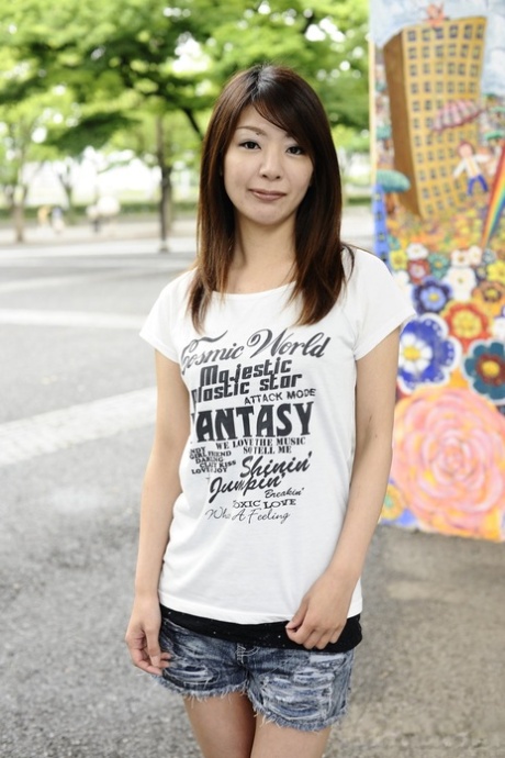 Japanese solo girl Tomomi Matsuda poses outdoors in a T-shirt and denim shorts 25650451